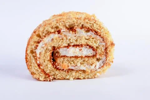 Oriented Swiss roll cake slice, emphasizing its tight spiral of tender sponge Stock Photos