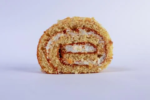 Oriented Swiss roll cake slice, emphasizing its tight spiral of tender sponge Stock Photos