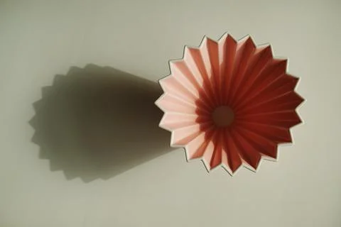 Origami coffee dripper on white background. Bright sunlight and distinct geom Foto stock
