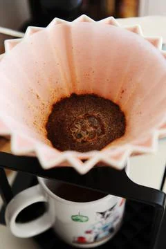 Origami dripper coffee brewing, close-up. Blooming, top view Stock Photos