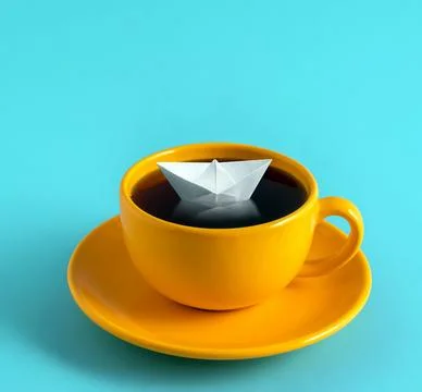 Origami paper boat floating in coffee cup. Minimal art fantasy poster. Stock Photos