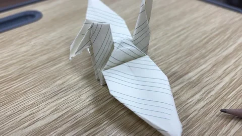 Origami Paper Crane Folded from Lined Notebook Paper on Desk Видео 331901083