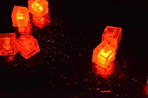 Original bright red glowing plastic cubes in darkness hellish and creepy. Stock Photos