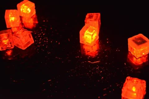 Original bright red glowing plastic cubes in darkness hellish and creepy. Stock Photos