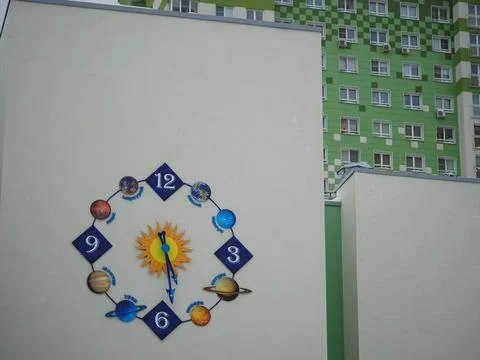 Original clock with an astronomical dial on the building. A school with an Stock Photos