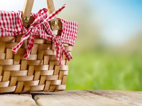 Original composition. Against the backdrop of summer nature, a straw picnic b Stock Photos