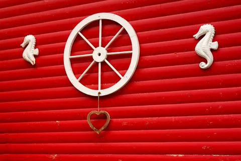 The original decor on the red wall of the stable, the wheel from the cart and Stock Photos