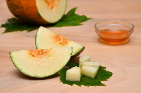Original serving pieces of melon on a leaf Foto stock