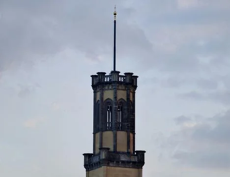 Ornamental Tower Emphasizing Vertical Windows And Detailed Stonework Agains.. Stock Photos