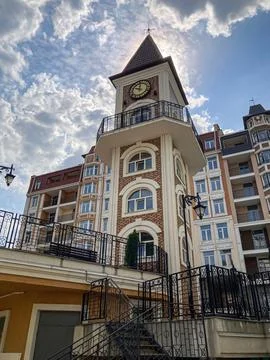 Ornate brick building with clock tower, overcast skies, small plaza, greene.. 库存照片