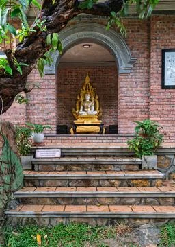 Ornate Buddha statue inside an arched brick shrine at Huyen Khong Son Thuong Stock Photos