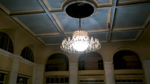 Ornate classical chandelier glows in old ball room Stock Footage 337798935