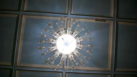 Ornate classical chandelier glows in old ball room Stock Footage 337798937