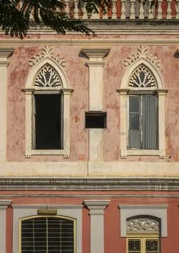 Ornate Gothic-arched windows on a weathered colonial facade, Benguela Provi.. Stock Photos