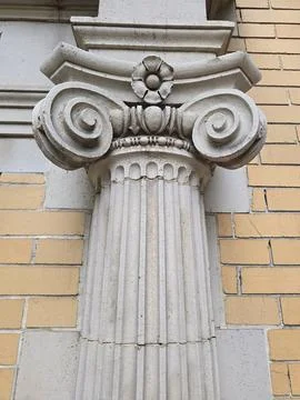 Ornate Ionic Column Capital Against Brick Wall Stock Photos