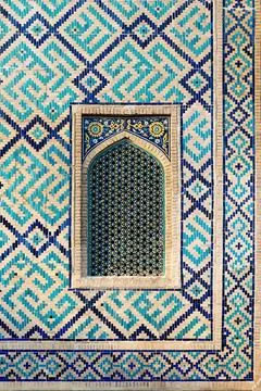 Ornate mosaic tilework and pointed-arch window on Sher Dor Madrasah at Regi.. Stockfoto's
