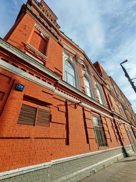 An ornate red brick structure with arched windows, white decorative elements 스톡 사진