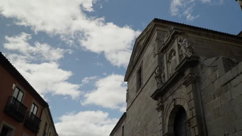 Ornate stone facade featuring religious sculptures under a blue sky with wh.. Stock Footage 335640538
