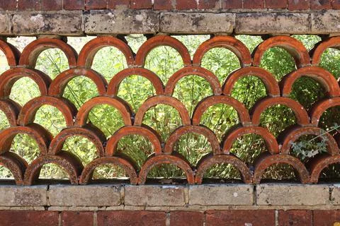Ornate wall comprising old bricks and terracotta semi circular tiles Stock Photos