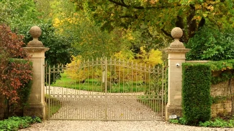 Ornate wrought iron gate opening in an English countryside manor garden. Stock Footage 318820562