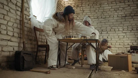 Orphan Makes Chess Move in Cold Shelter While Others Survive in Background Video stock 329464901