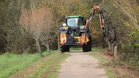 Orsi Acrobat 4 long reach mower mounted to John Deere tractor clearing verges Stock Footage 143015738