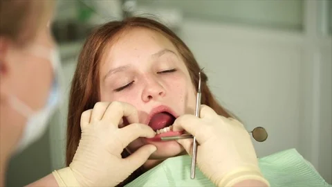 Orthodon checks the teeth of a teenager who has come to the clinic for treatment Stock Footage