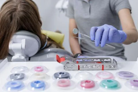 Orthodontic tools and sterilization cassette with power chains beside patie.. Stock Photos