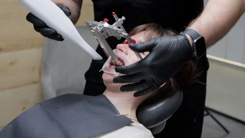 Orthodontist using a dental facebow device to measure jaw alignment and bite Stock Footage 339274051