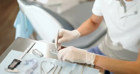 Orthodontist working with jaw model applying brace system Stock Footage 147888255