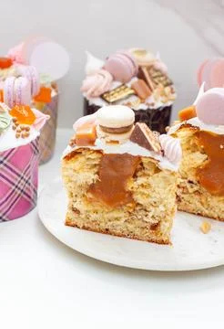 Orthodox easter bread richly decorated with sweets, macaroons, chocolate and  Stock Photos