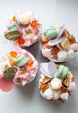 Orthodox easter bread richly decorated with sweets, macaroons, chocolate an.. Stock Photos