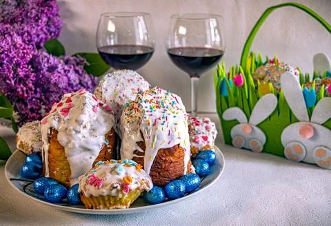 Orthodox Easter cakes with red wine, lilac flowers and green bunny basket. 库存照片