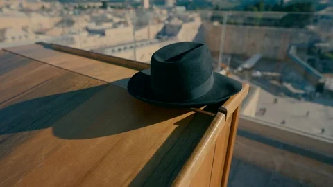 An Orthodox hat on the table in the balcony with a view of the Western Wall . Stock Footage 231860070