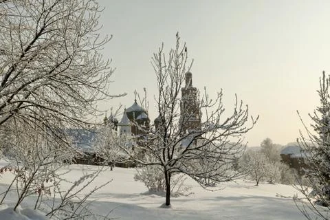 Orthodox monastery behind bare trees in deep snow at winter Stock Photos