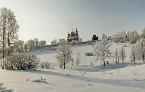 Orthodox monastery on the slope with bare trees in deep snow area Stock Photos