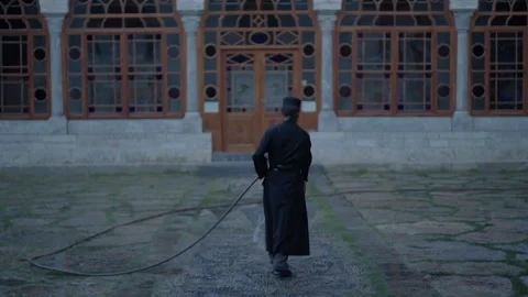 Orthodox monk cleaning the courtyard of a monastery in Mount Athos Stock Footage 330188736