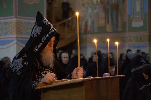 Orthodox monk, elder, schema, prayer, candle, temple, Divine service Stock Photos