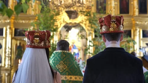 Orthodox wedding ceremony with bride and groom wearing crowns in church Stock Footage 341577487