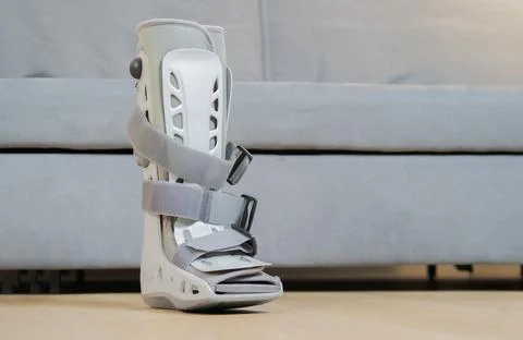 A orthopaedic grey plastic boot ankle brace injury protecting boot on the flo Stock Photos