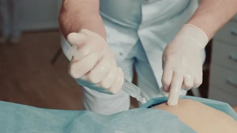 Orthopedist-traumatologist making an injection with a large needle in the Stock Footage 153109625