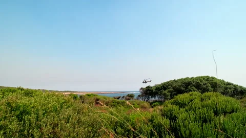 Oryx helicopter with helibucket fly over coastline to fight bushfire in Hermanus Vídeo Stock 331027497