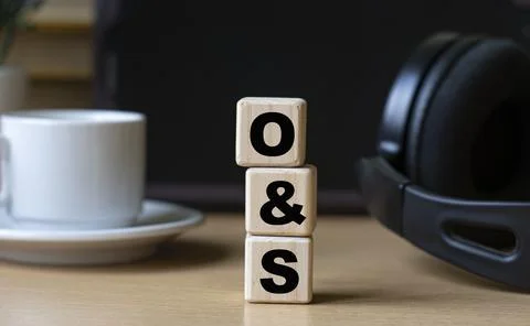 O&amp;S -word on cubes on the background of the tablet, headphones and a white cu Stock Photos