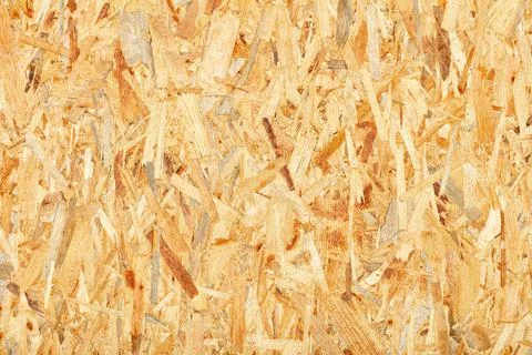 OSB, board texture and pressed sandy brown shavings background, close-up. Stock Photos