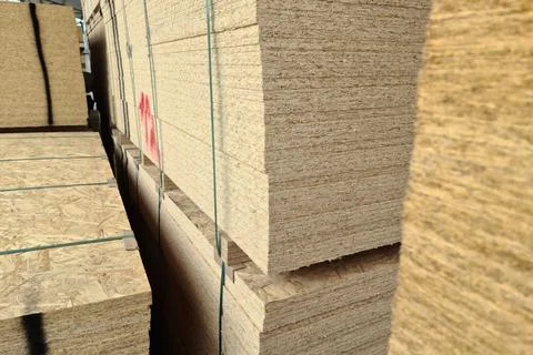 OSB sheets lie in stacks in a warehouse for sale. Hardware store Stock Photos