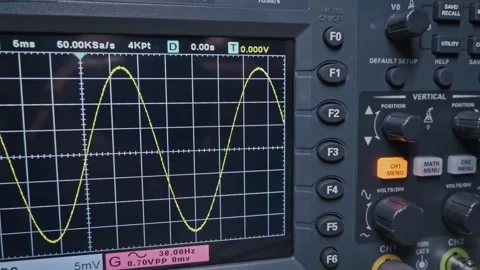 Oscilloscope Screen Displaying a Sine Wave During an Electronics Test Stock Footage 327611458