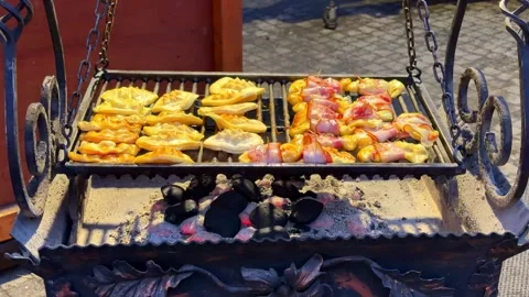 Oscypek cheese with bacon grilling over hot charcoal on a traditional metal 库存影片 345973433