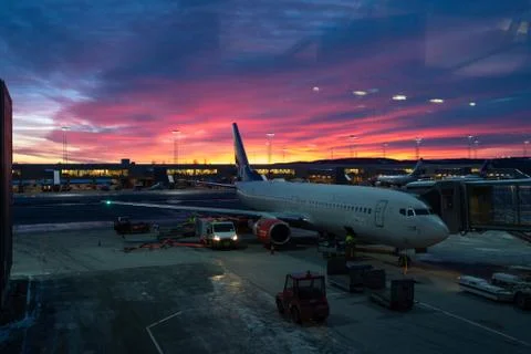 Oslo airport with beautiful sunset. SAS airplane is in dock Stock Photos