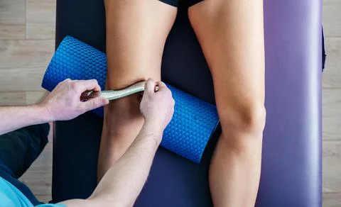 Osteopath performing IASTM technique to fix knee cap Patellofemoral pain Stock Photos
