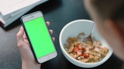 OTS lady day breakfast checking emails iPhone green screen morning light Stock Footage 73783202